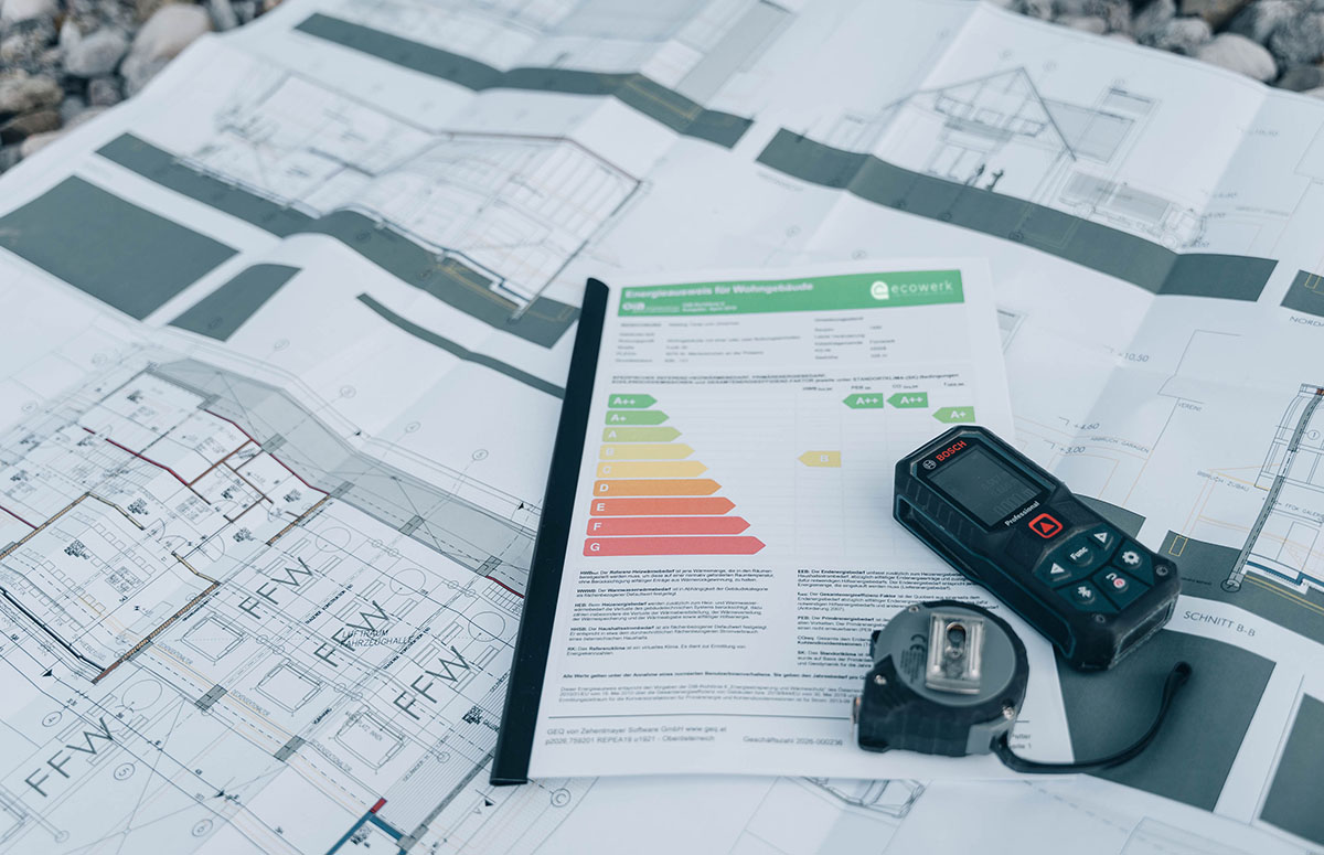 Bauplan mit Energieausweis, Distanzmessgerät und Maßband